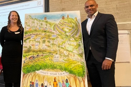 Image shows (left to right) Dr Alix Dietzel and Marvin Rees with a piece of artwork depicting a greener Bristol in the 2030s, having achieved a just transition.